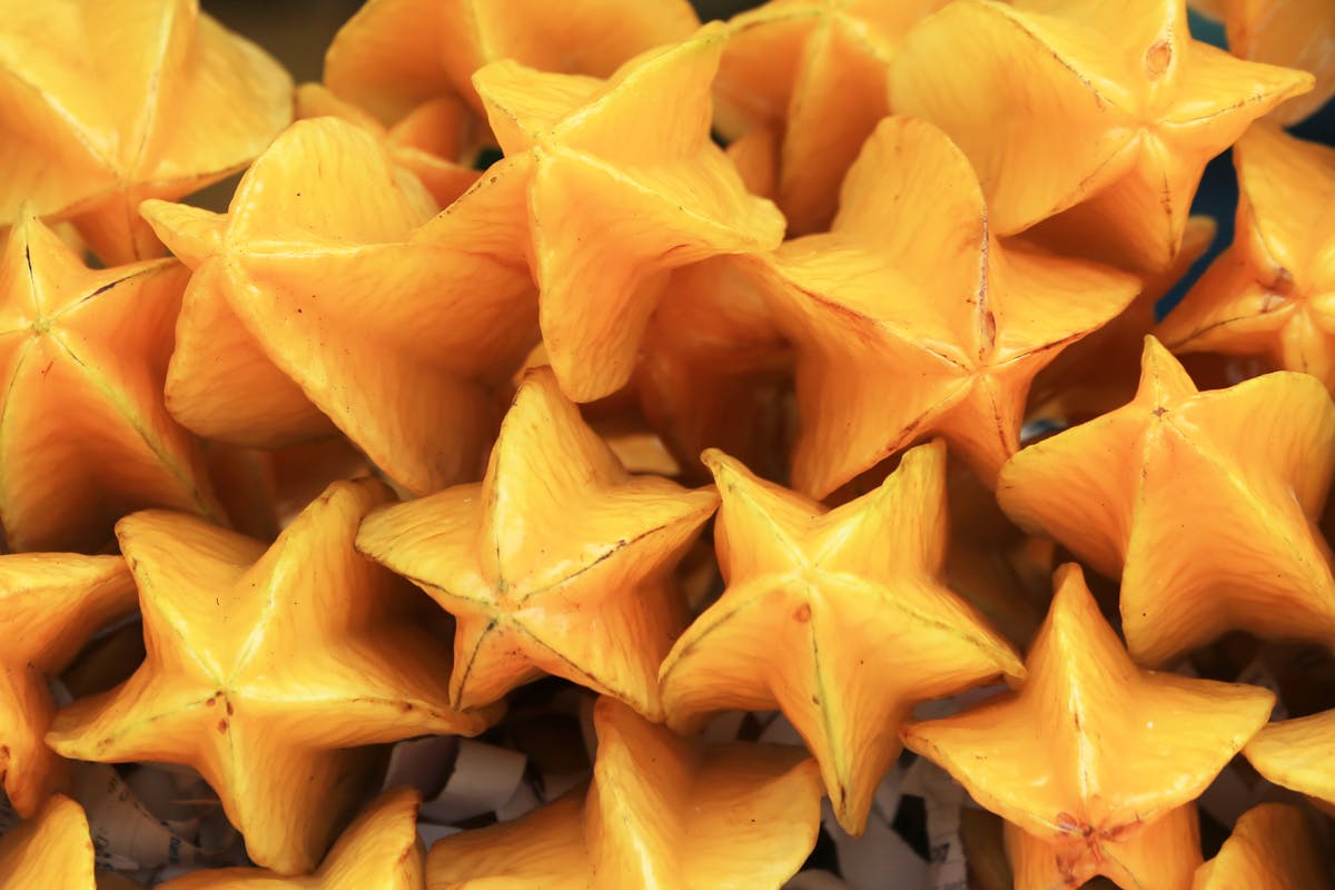 10 Foods With Secrets You Never Knew About 3 Bright and colorful starfruit (Averrhoa carambola) piled together, showcasing vibrant tropical fruits.
