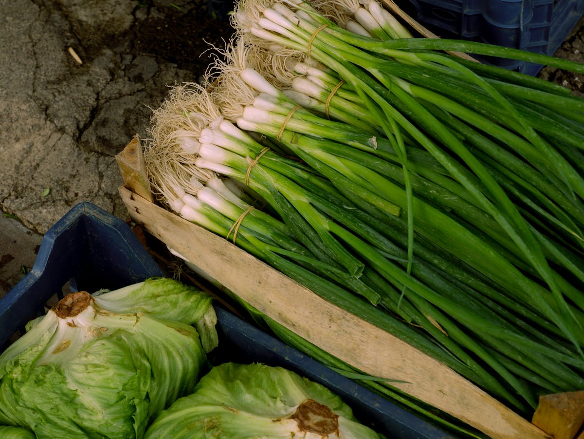 10 Unexpectedly Delicious Recipes With Surprising Ingredients 1 Bunches of green onions and cabbages in crates at a market. High-angle view.