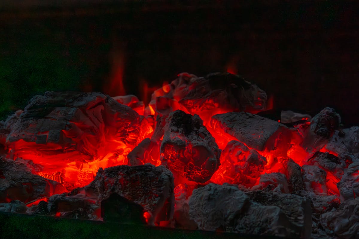 10 Towns in the U.S. That Feel Too Weird to Be Real 3 Close-up of glowing red hot coals in a dark fire pit, radiating intense heat.