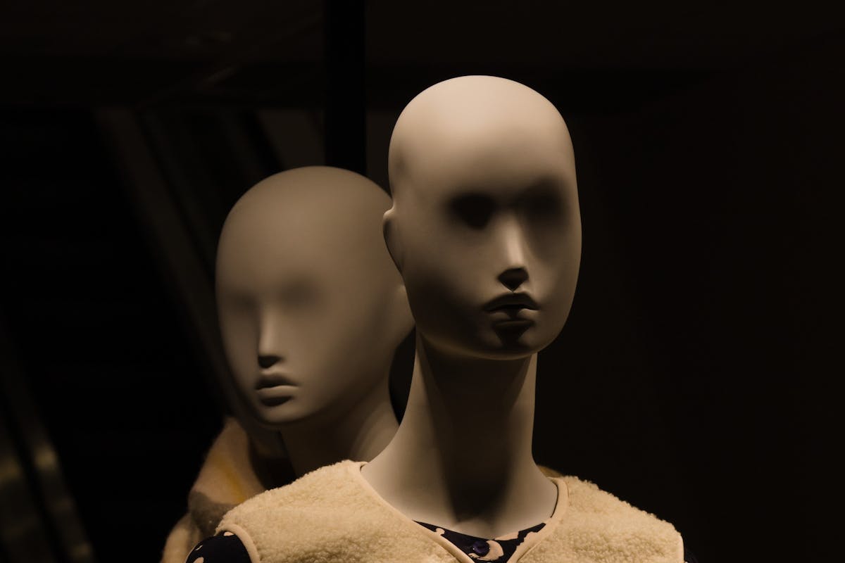 10 Kids' TV Characters That Gave Us Nightmares, And Why They Still Haunt Us 1 Close-up of two mannequins in dim lighting, creating a mysterious and eerie ambiance.