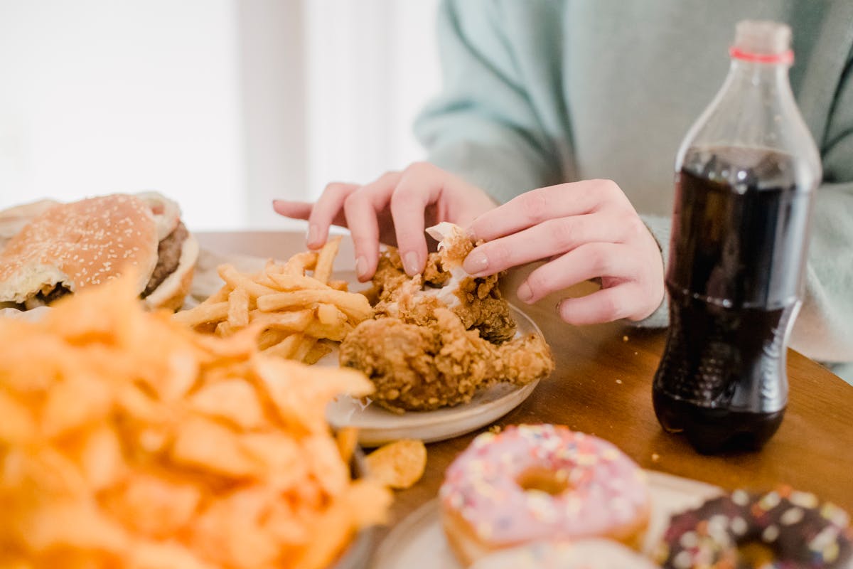 9 Strange house rules people say they’ve had to follow as guests 1 Crop anonymous female eating appetizing spicy fried chicked at table with different snacks