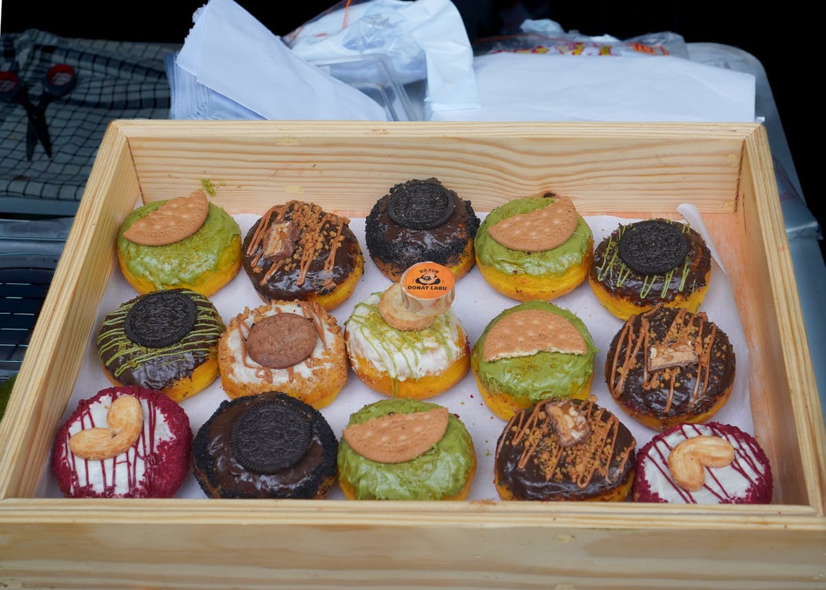 8 Worst Foods to Eat Before Bed That Quietly Destroy a Good Night’s Sleep 3 Delicious assorted gourmet donuts with various toppings in a wooden box, perfect for dessert lovers.