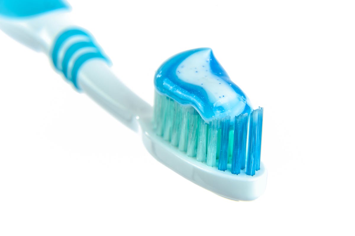 Unveiling the Strange Ingredients Hiding in Your Everyday Foods and Products 2 Detailed close-up image of a toothbrush with vibrant blue toothpaste for dental hygiene.