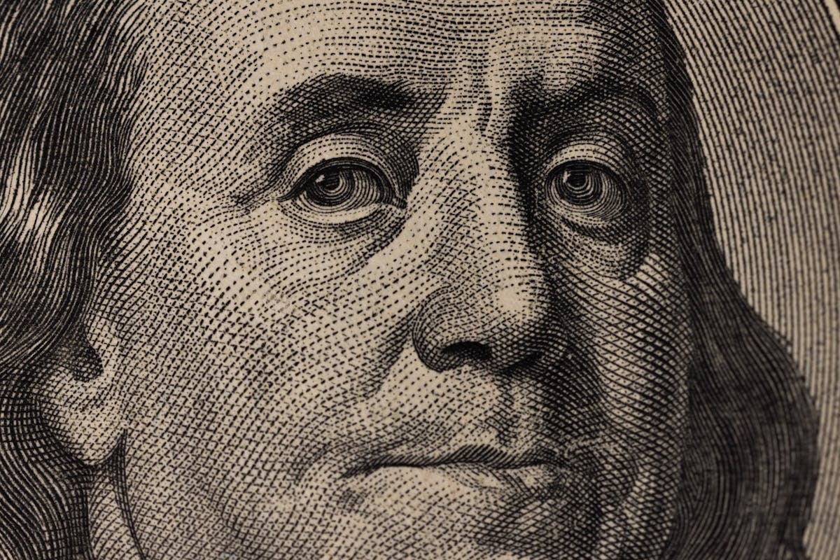 6 Weird Celebrity Wills and Final Wishes That Still Shock Us 1 Detailed view of Benjamin Franklin's face on a US dollar bill, showcasing fine engraving.