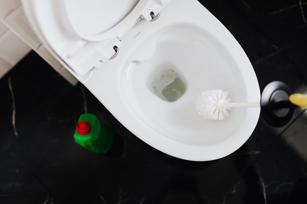 15 Cleaning Products You Should Avoid at All Costs and What to Use Instead 4 From above crop anonymous person in yellow gloves cleaning toilet bowl with toilet brush and liquid detergent in green plastic bottle