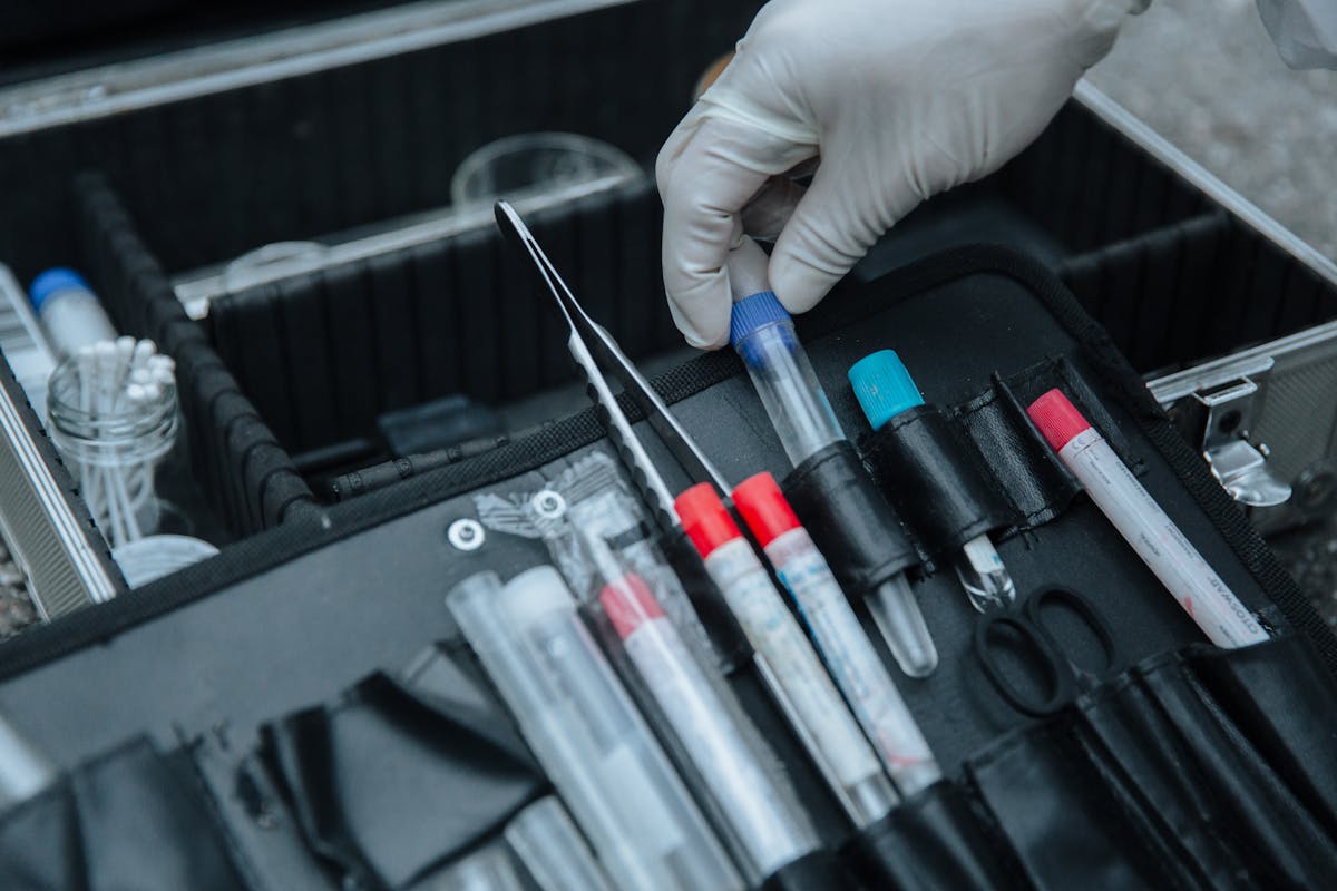 10 Bizarre Death-Related Things You Could Find Online 3 Gloved hand handling test tube in forensic equipment case at crime scene.