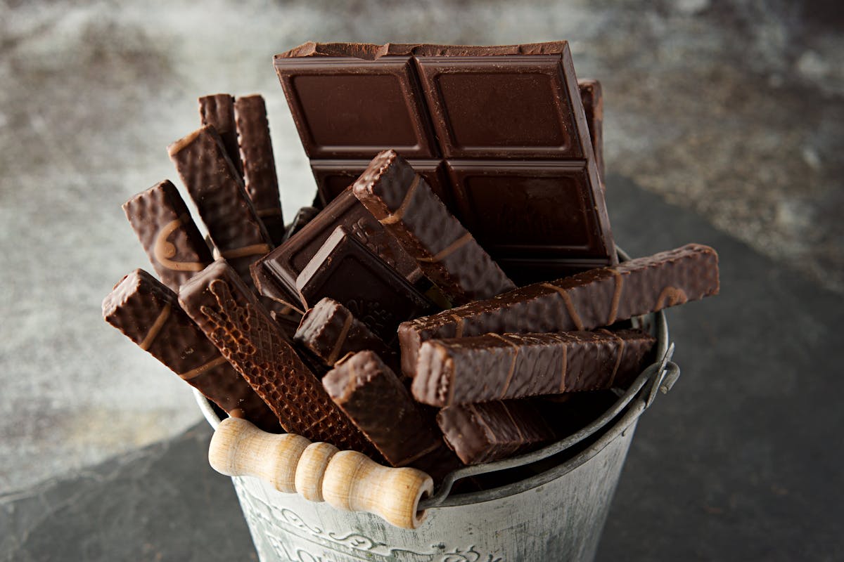 Top 10 “Unhealthy” Foods That Are Actually Good For You 2 Indulgent assortment of chocolate bars and wafers in a rustic bucket. Perfect for dessert inspiration.