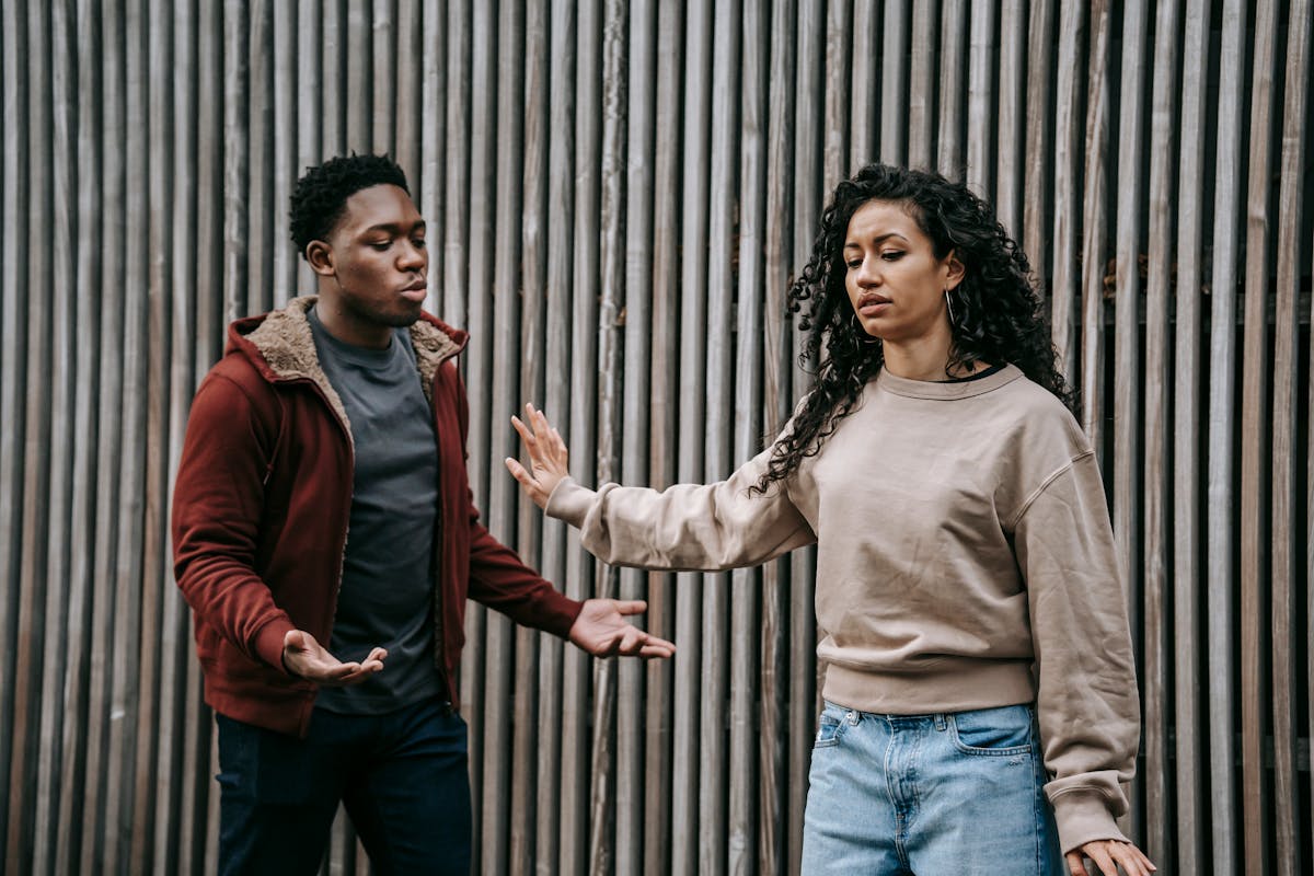 If You Ignore These 8 Red Flags, Your Boyfriend Will Be a Dud in a Year 4 Insulted ethnic girlfriend with outstretched arm and irritated African American boyfriend having quarrel near wooden wall on street during breakup