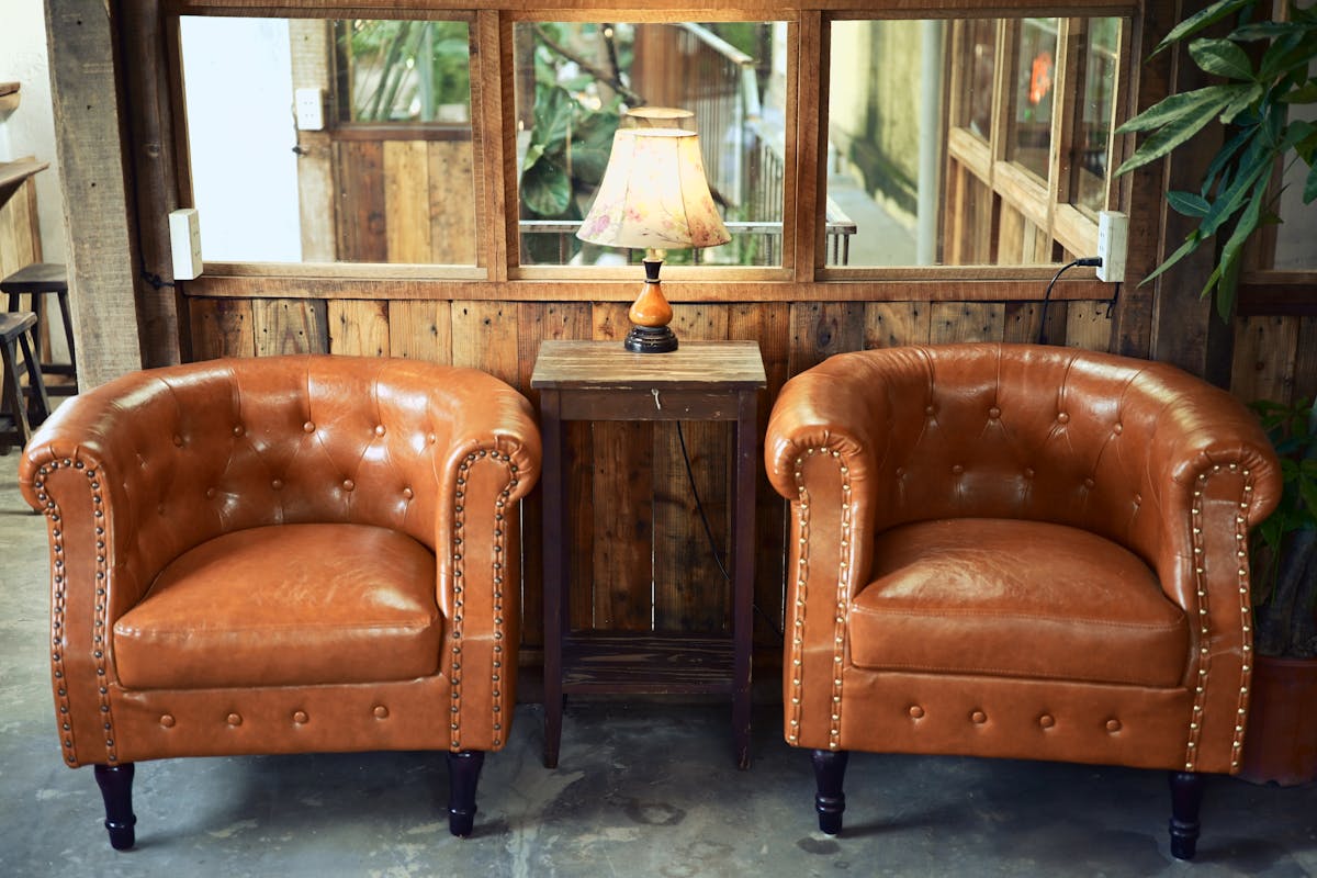 10 Things You’re Ruining by Cleaning Them With Disinfecting Wipes 3 Inviting rustic lounge setup with leather armchairs and a wooden lamp for a warm ambiance.