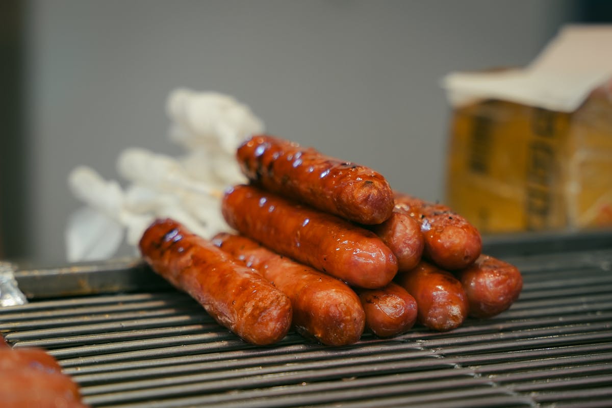 15 Sausage Recipes You’re Probably Ignoring (And It’s a Big Mistake) 1 Juicy grilled sausages stacked on a barbecue grill ready to serve.