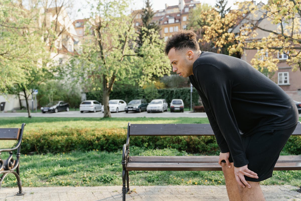 8 Odd Health Symptoms We Should Never Ignore 2 Man in black sportswear resting on park bench after exercise session.