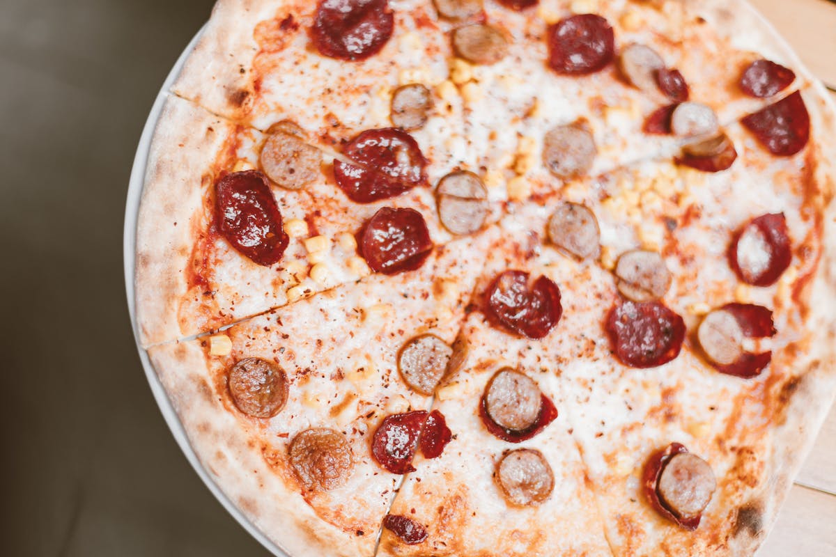 The Wildest Food and Condiment Mishaps That Escalated Into Chaos 2 Mouth-watering pepperoni and sausage pizza photographed from above.