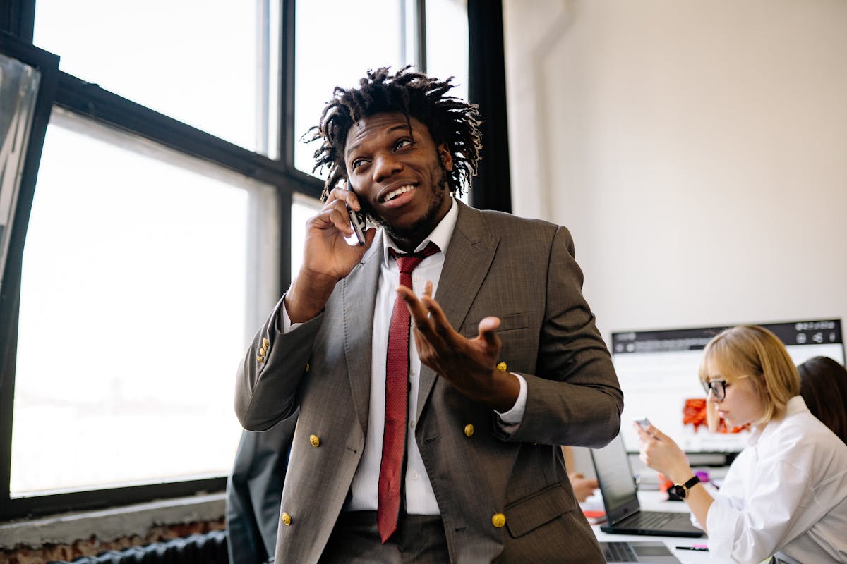 10 Middle Class Jobs Disappearing Fast 2 Professional businessman smiling while talking on the phone in an office setting.