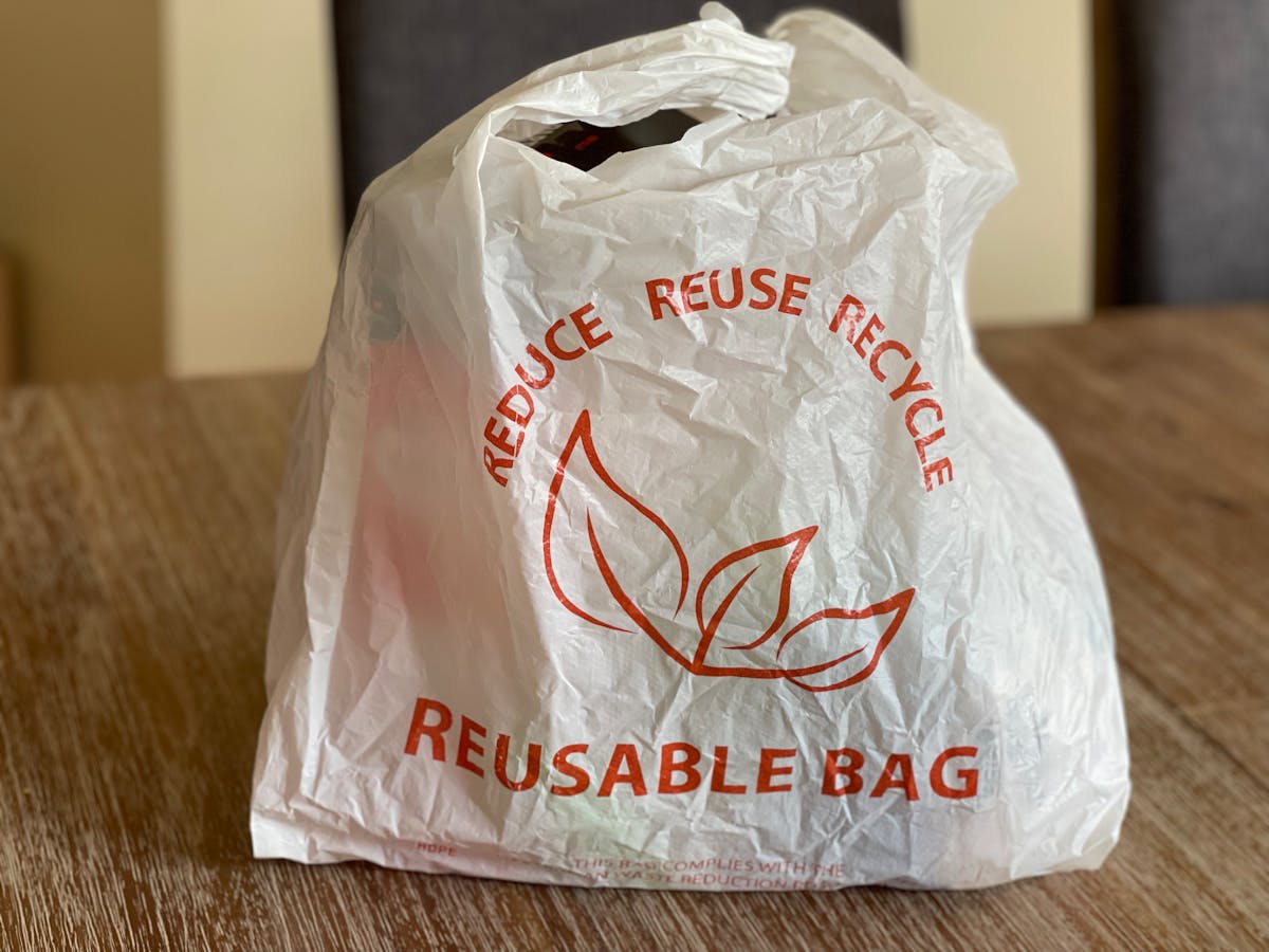 8 Items You Should Stop Storing In Kitchen Cabinets 3 Reusable bag promoting reduce, reuse, recycle on a wooden table indoors.