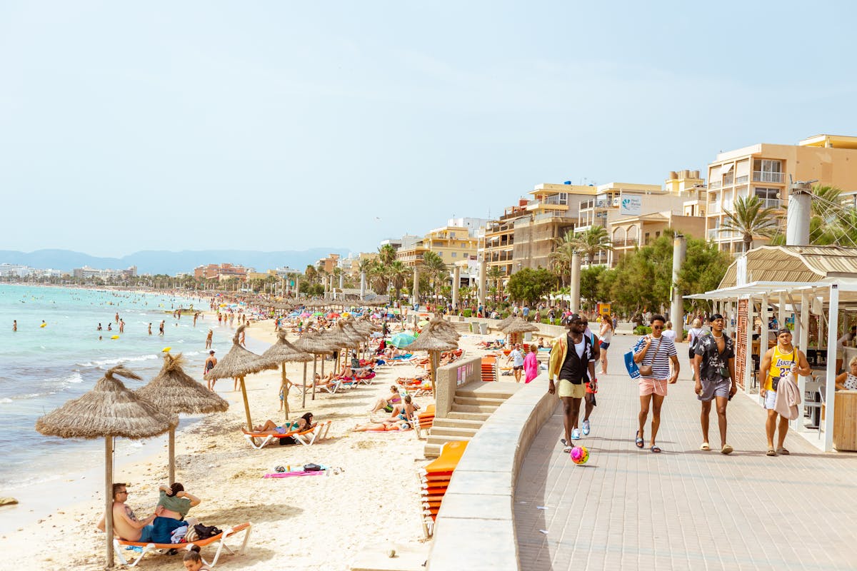 Sunny day at a bustling Ibiza beach with people enjoying leisure activities. Ideal for vacation and tourism content.