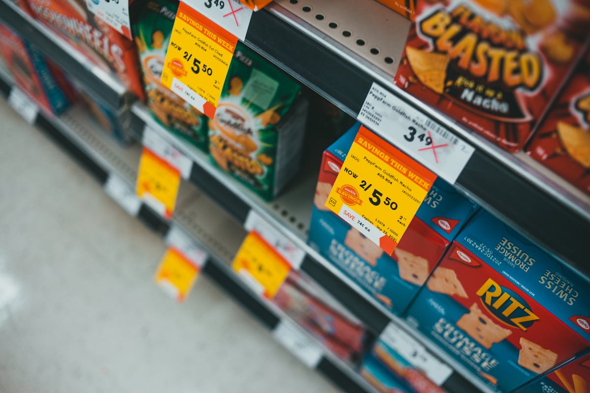 10 Grocery Tips To Avoid Ruining Your Budget 4 Supermarket aisle featuring discounted snacks with visible sale tags and prices.