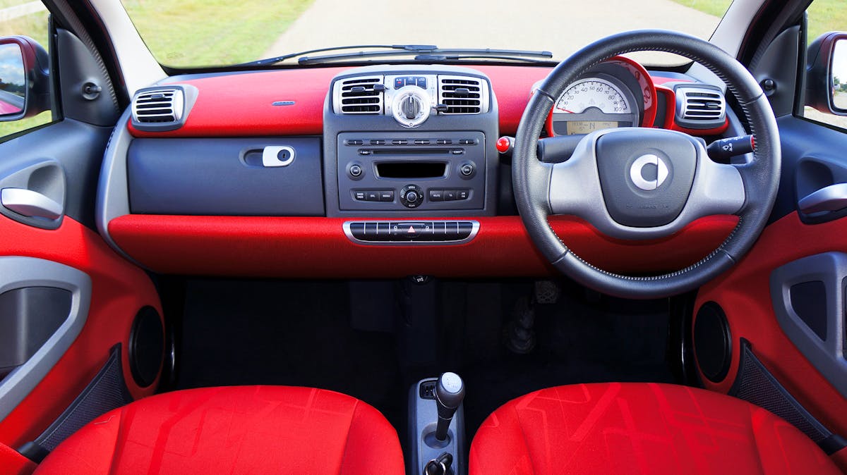 10 Things You’re Ruining by Cleaning Them With Disinfecting Wipes 4 View of a compact car's red interior with a detailed dashboard and steering wheel.