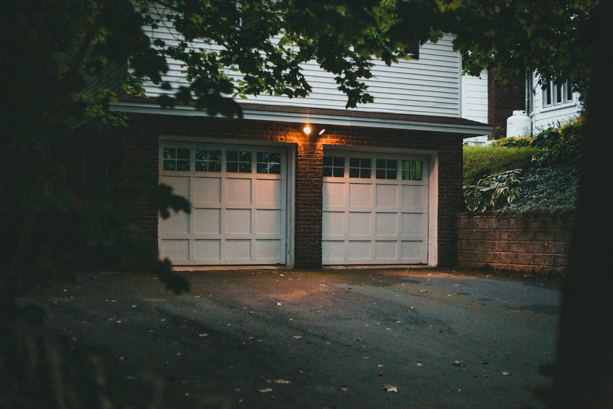 11 Things You Shouldn’t Overlook Before Purchasing a House 3 Warm evening view of a suburban garage with soft lighting creating a cozy atmosphere.