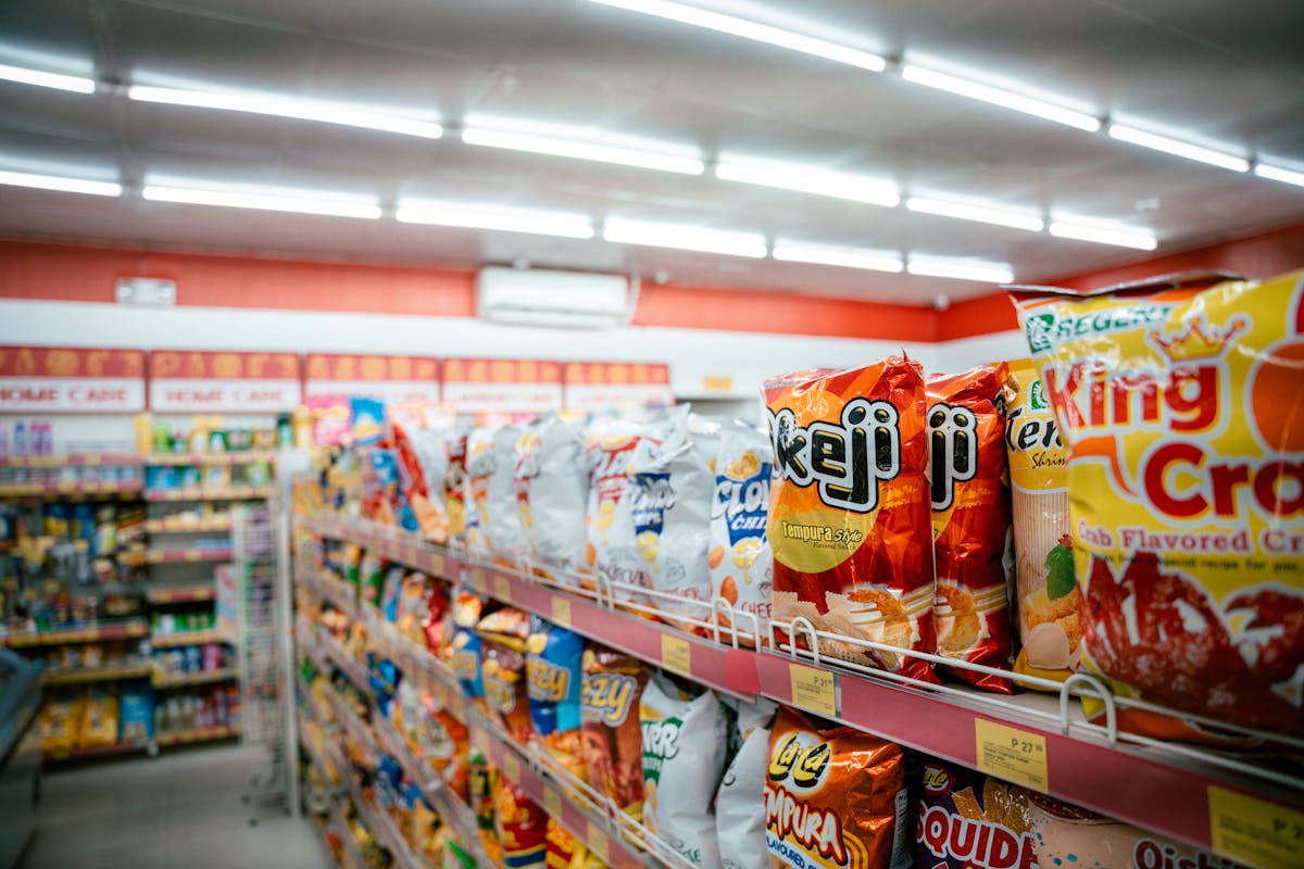 9 Shocking Convenience Store Facts You Need to Know 4 Wide shot of vibrant snack aisle in a supermarket with various chip bags on display.