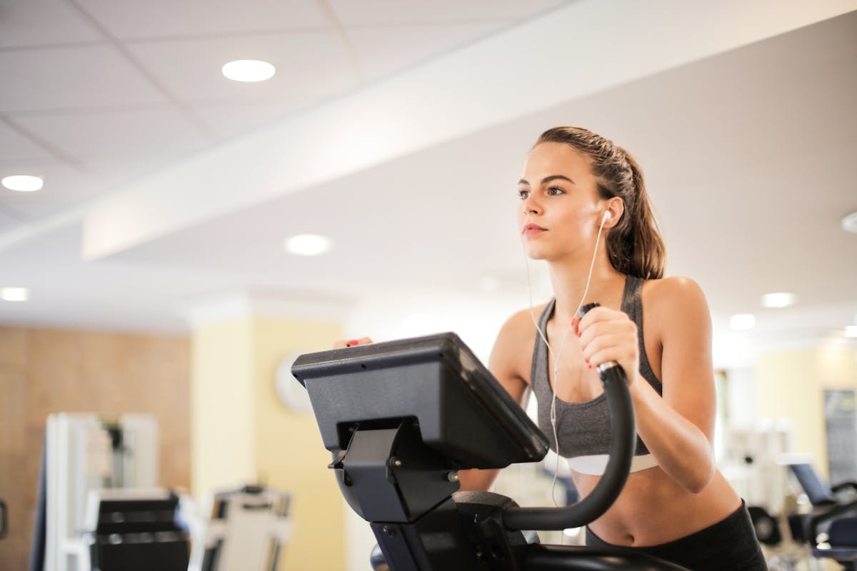 8 Unusual Reasons People Got Banned from Places for Life 1 Woman in a gym focused on cardio exercise using elliptical machine. Healthy lifestyle and fitness concept.