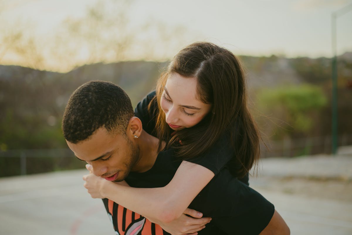 If You Fail to Do These 10 Things, You're the Victim in The Relationship 4 Young couple joyfully embracing outdoors on a sunny day, symbolizing love and togetherness.