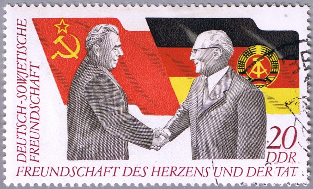 EAST GERMANY - CIRCA 1972: A stamp printed in East Germany shows the handshake of Brezhnev and Honecker on the background of flags, is dedicated to the 25 anniversary of the Society of German-Soviet Friendship, series, circa 1972