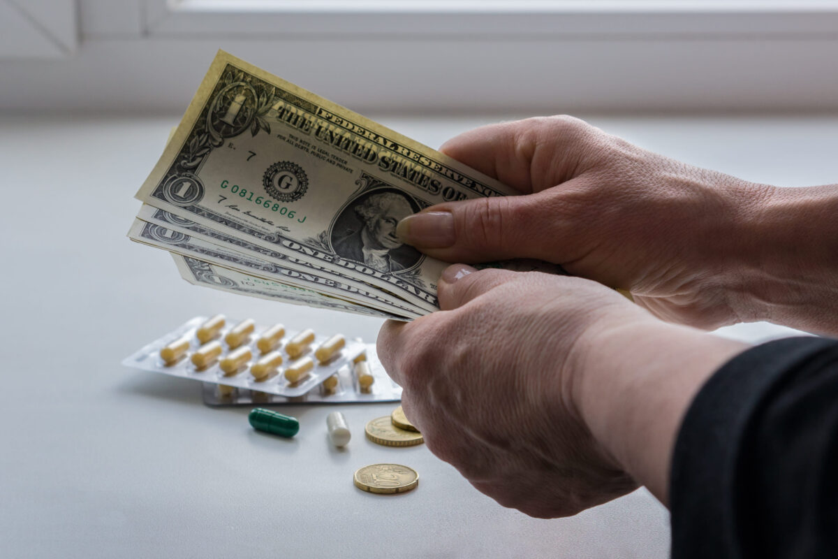 Women's hands hold dollars, drugs and coins lie on the windowsill