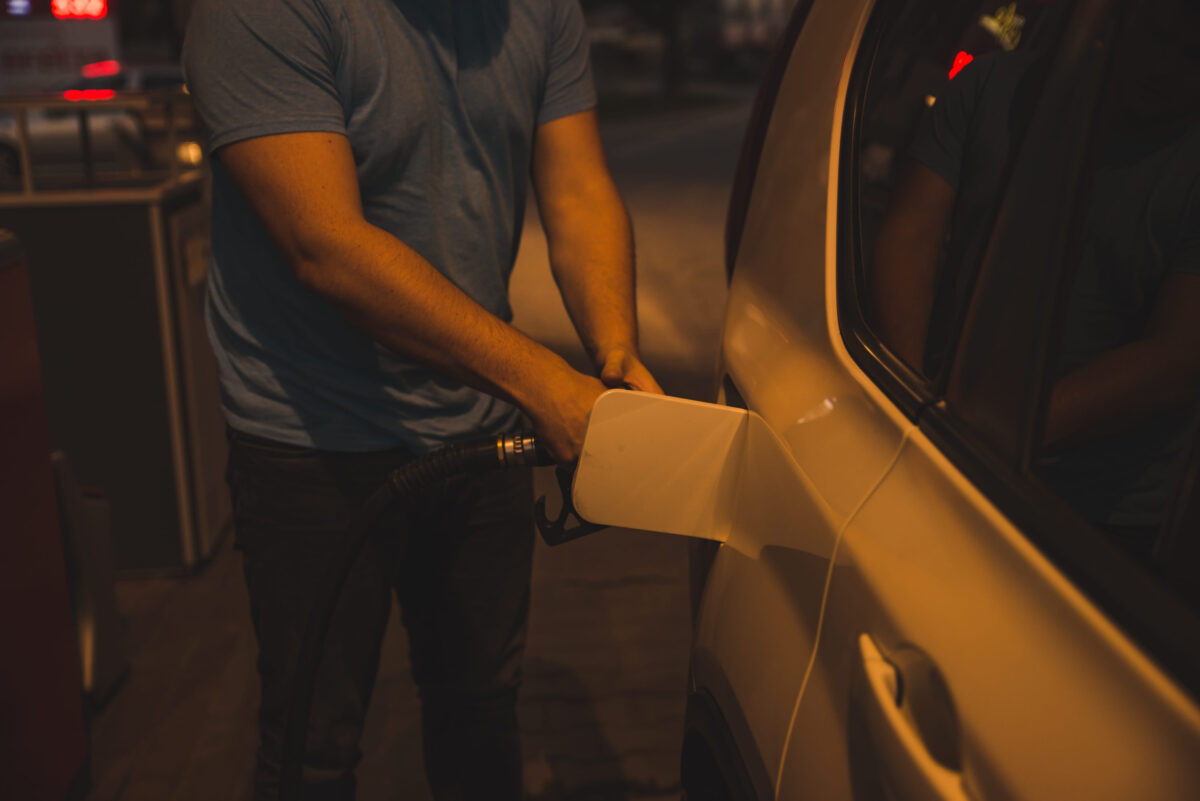 man fueling up the car in the evening on gas station
