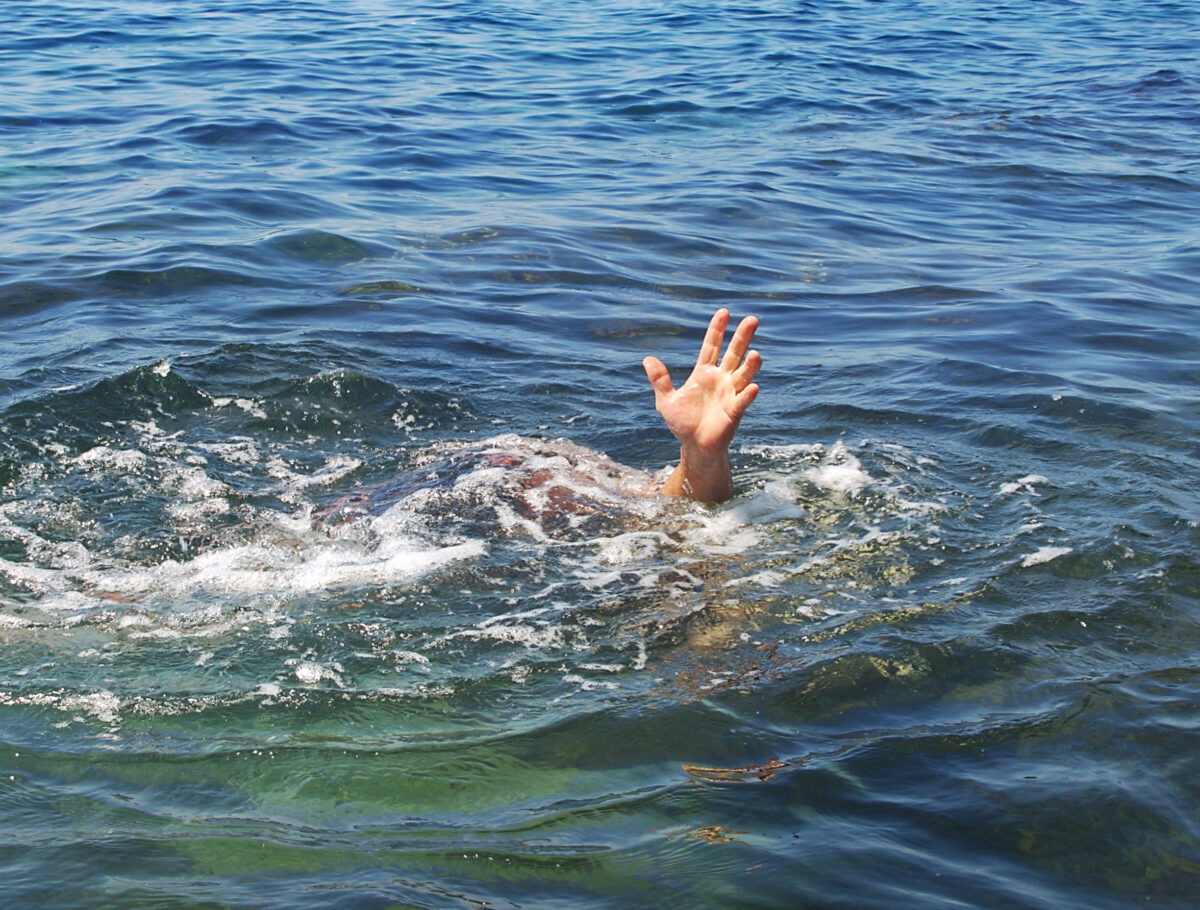 Hand drowning man sticking out of the water