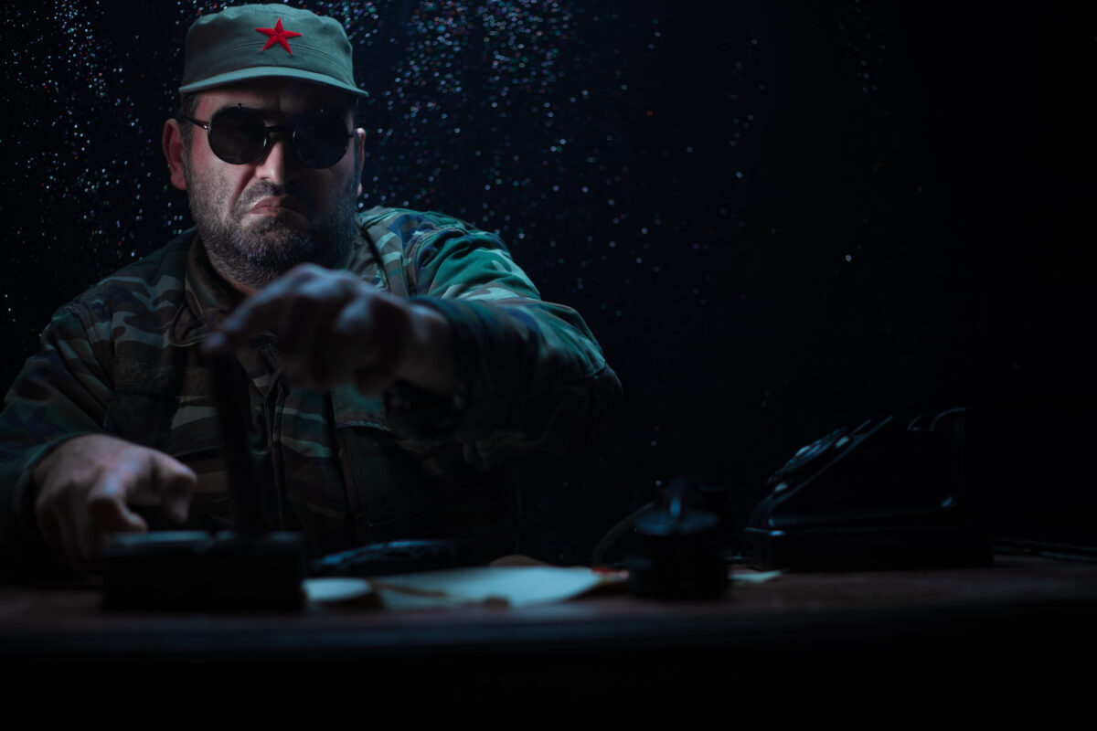 8 Leaders Who Wanted Worship, Not Respect 4 The evil dictator sitting on table. Angry communist general sitting at headquarter or Cuban commander in dark room. Studio decoration