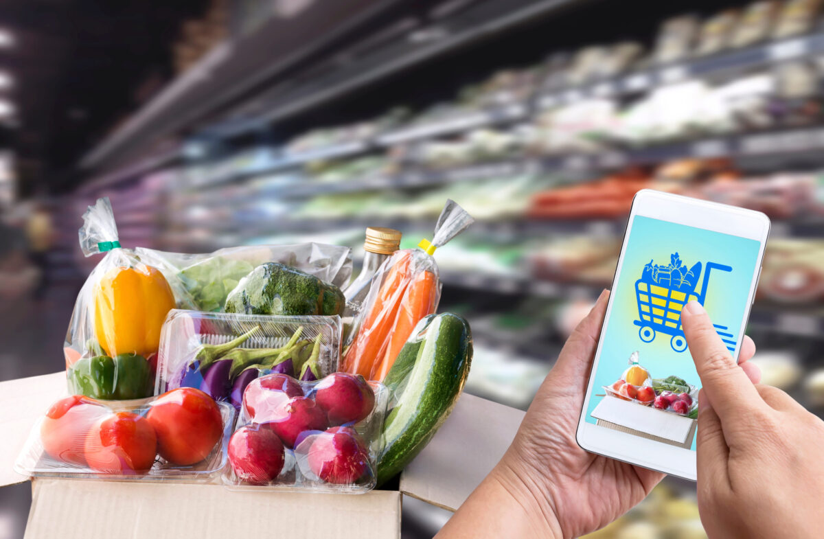 Online order grocery shopping concept on touch screen. Food delivery ingredients service at home for cooking with packages box and icon media symbol. Business and technology for lifestyle in city.