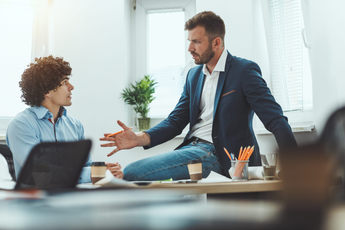 Two young businessman communicating while working on a new business project in the office.