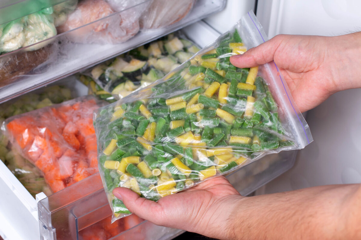 Bags with frozen vegetables in refrigerator. Frozen Asparagus Beans, closeup