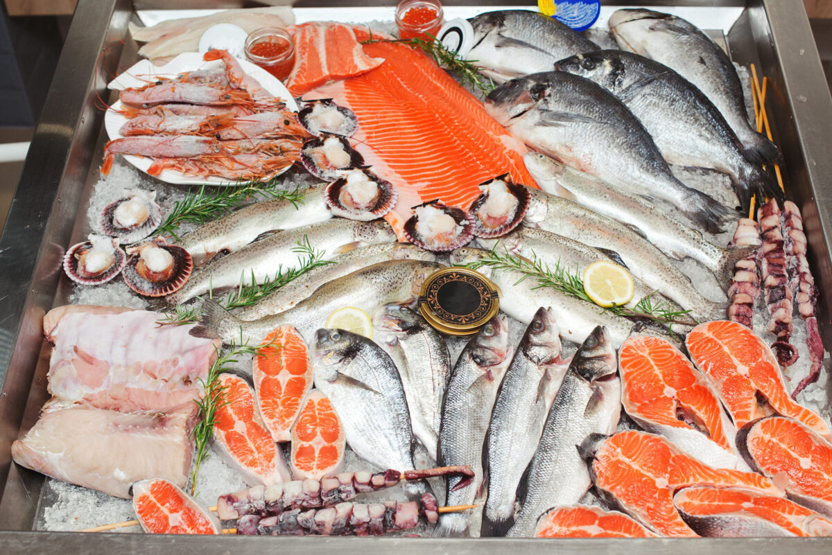 Fish food at shop, close up. Raw fish ready for sale in the supermarket. Showcase with chilled red fish in grocery store. Market place, showcase with sea food. Retail sale, marketplace.