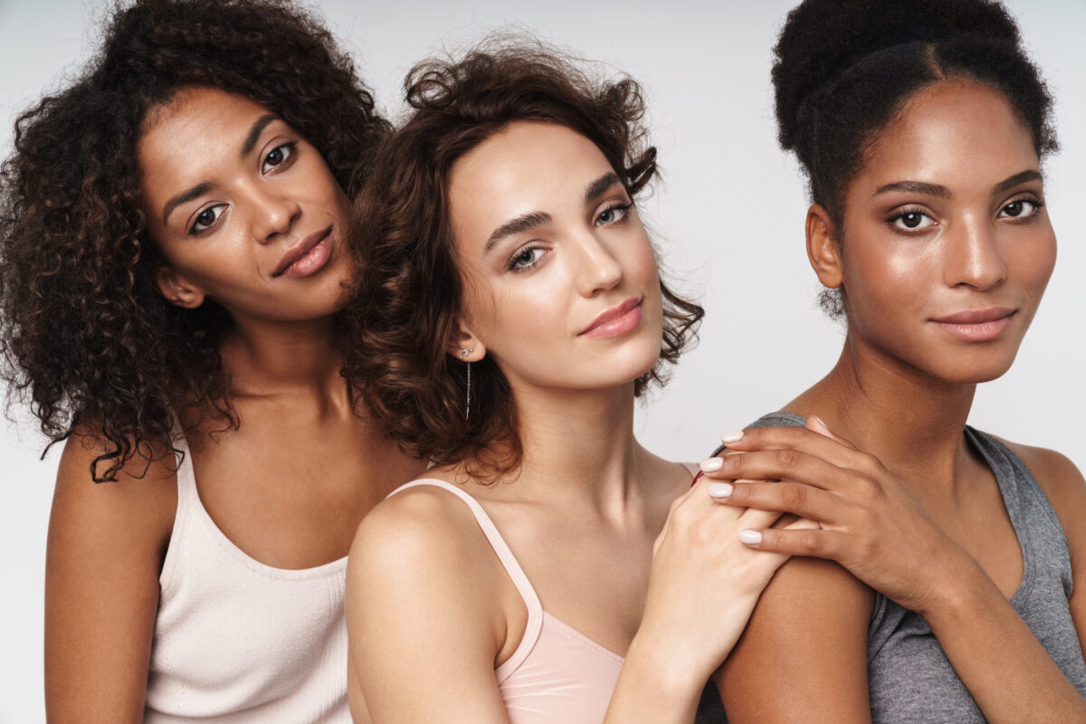 Three adorable multiethnic women hugging together 