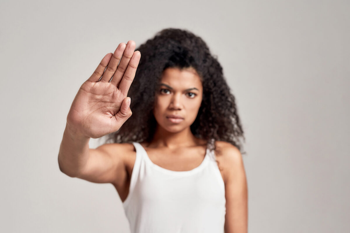 9 Dangerous Ways Men Misread Women’s Dressing as an Invitation 4 Portrait of young african american woman with curly hair wearing white shirt having serious confident look while showing, making stop gesture isolated over grey background