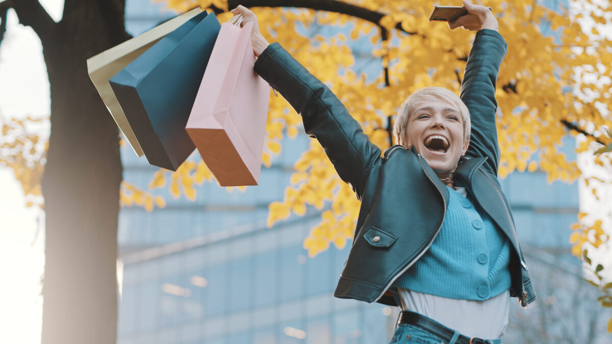 Happy young girl jumping with the shopping bags. Sales and discounts concept. High quality photo