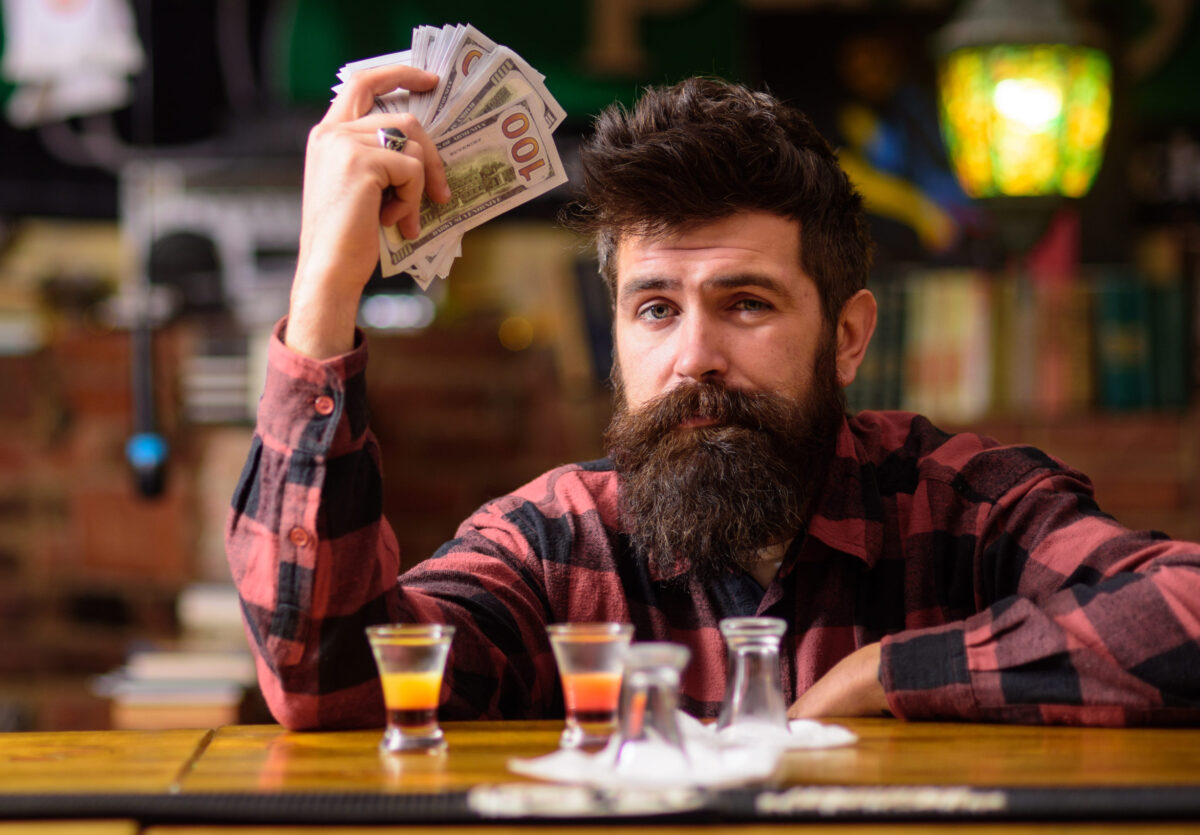 8 Health Red Flags That May Point to Drinking Too Much 4 Hipster holds money, counting cash to buy more alcohol.
