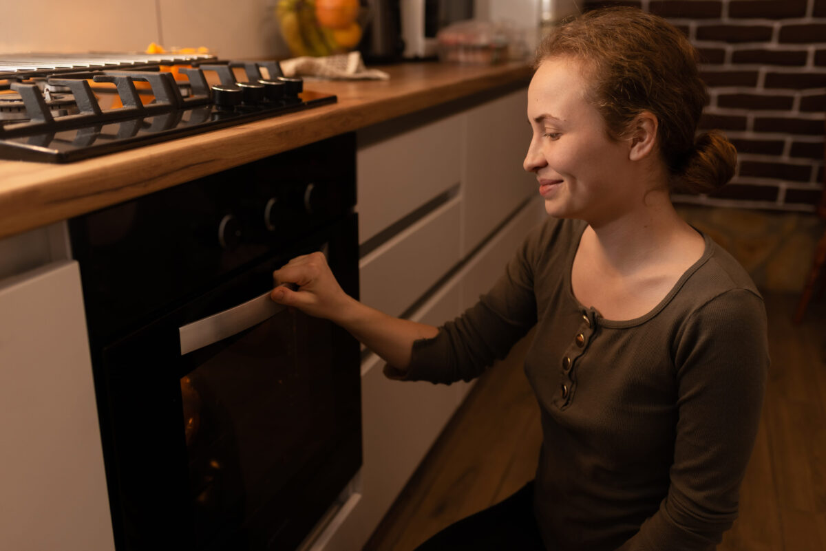 Girl walks to the oven to check the meat pie in the oven