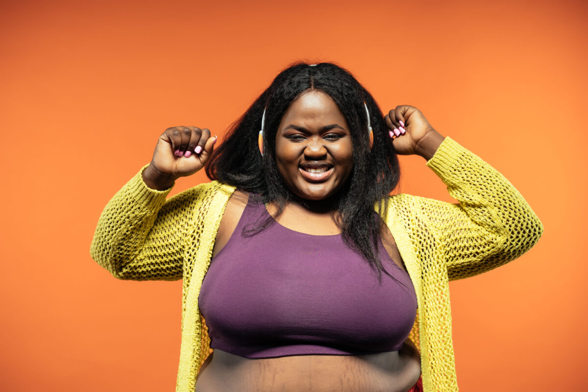 9 Backhanded Compliments Curvy Women Are Tired of Hearing 2 Image of a beautiful woman posing in casual clothes on a colored background.