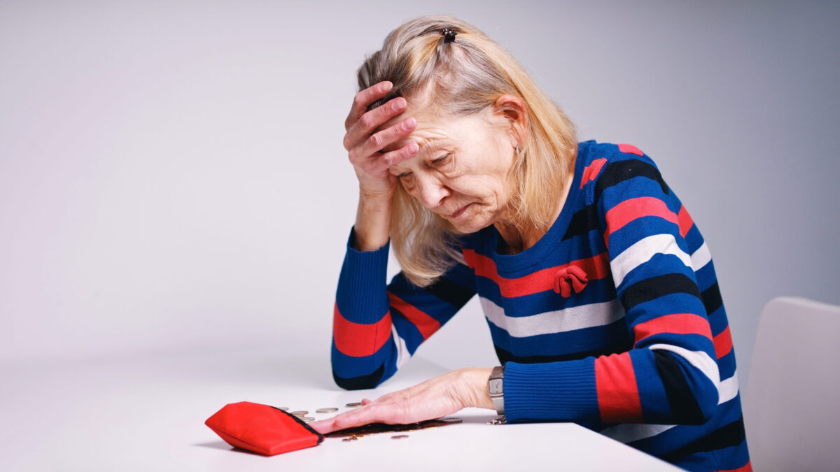 hopeless elderly woman looking at the empty wallet. High quality photo