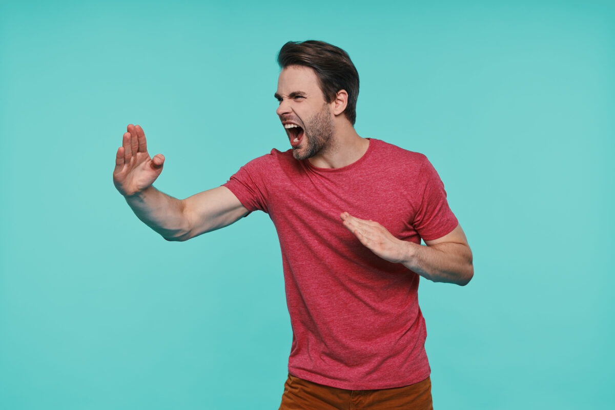 8 “Gentleman” Habits That Can Make Men Look Insecure and Highly Desperate 4 Furious young smiling man in casual clothing gesturing against blue background