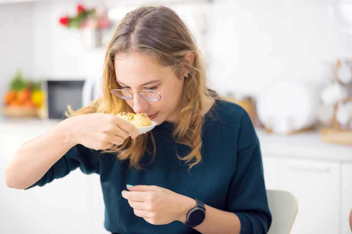 Making cakes and cookies is a lot of fun. In her kitchen, a young woman holds delicious fresh bread.