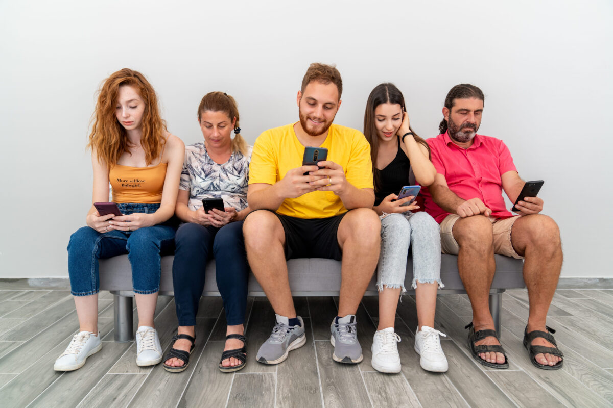 Group of friends sitting couch and looking to their mobile phones. Technology addiction concept. High quality photo