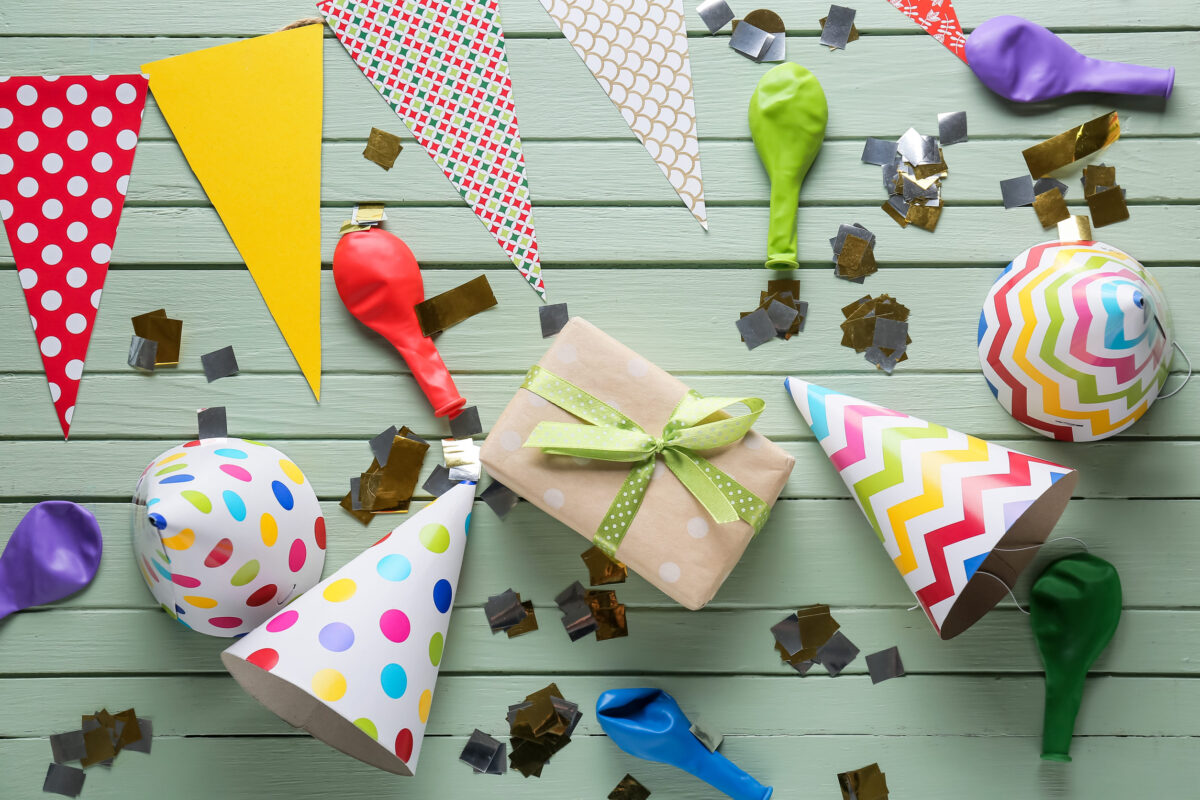 Composition with party hats on color wooden background