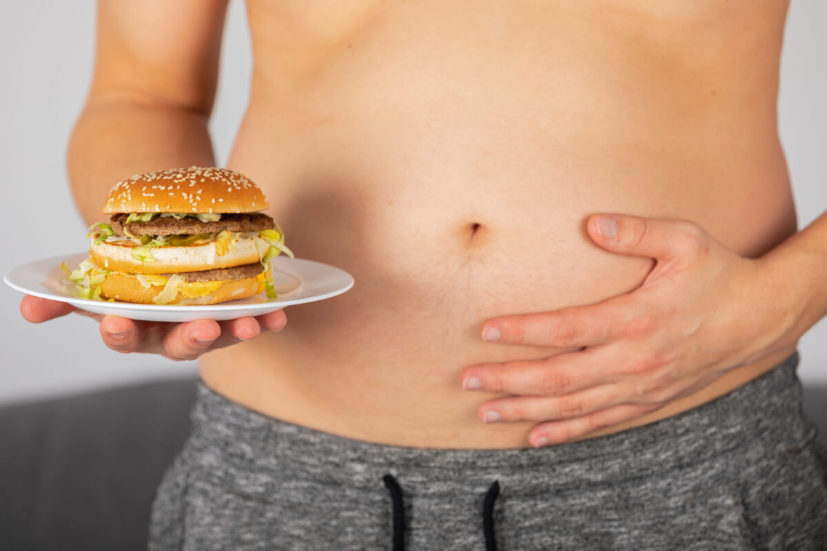 8 Alarming Risks of Excessive Protein and How We Are Pushing Our Bodies Beyond Their Limits 3 Photo of a man's hand holding a cheeseburger