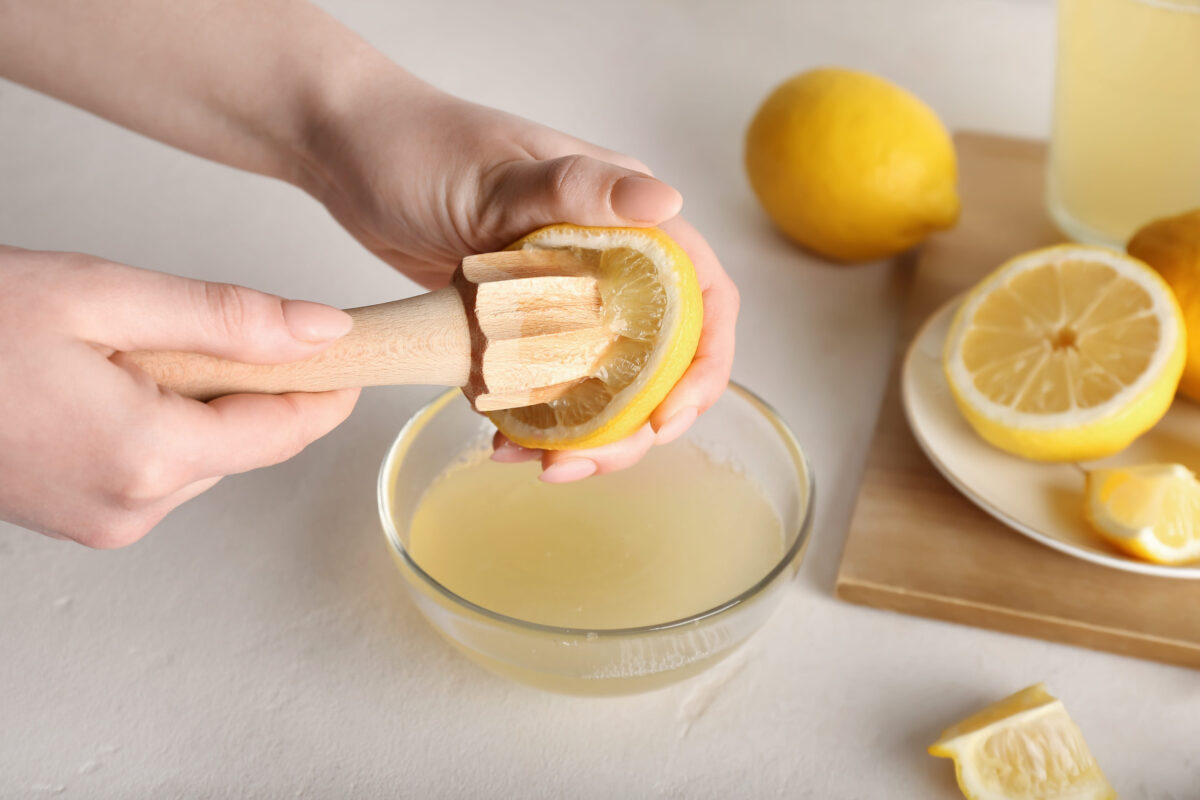 11 Surprisingly Cheap Ingredients That Make Your Meals Taste Expensive 2 Woman squeezing lemon juice on light background, closeup