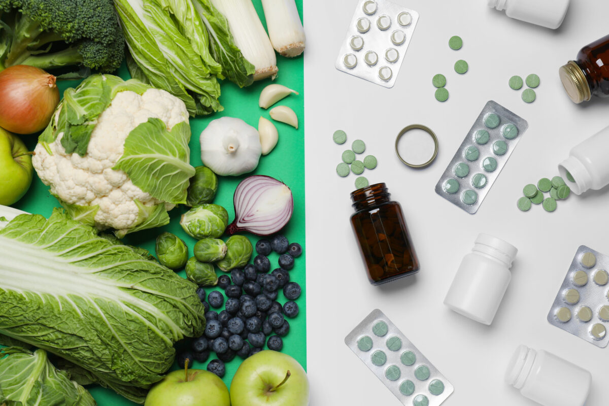 Different prebiotic supplements and foodstuff on color background, flat lay