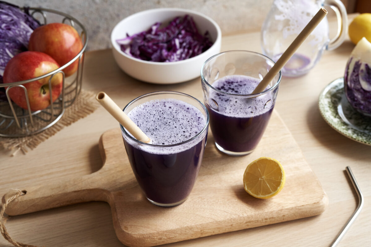 Purple cabbage juice in glasses with ecological zero-waste bamboo straws