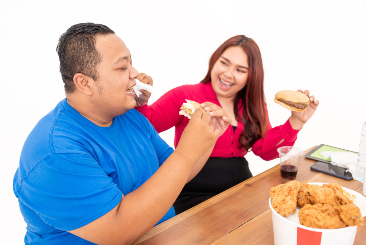 wo good friends are enjoying fast food together, sharing some hearty laughs and tasty bites